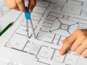 engineer sketching building project on a blueprint with a pencil b