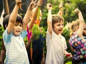 Group of kindergarten kids learning gardening outdoors