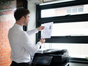 Businessman in office working with copier.