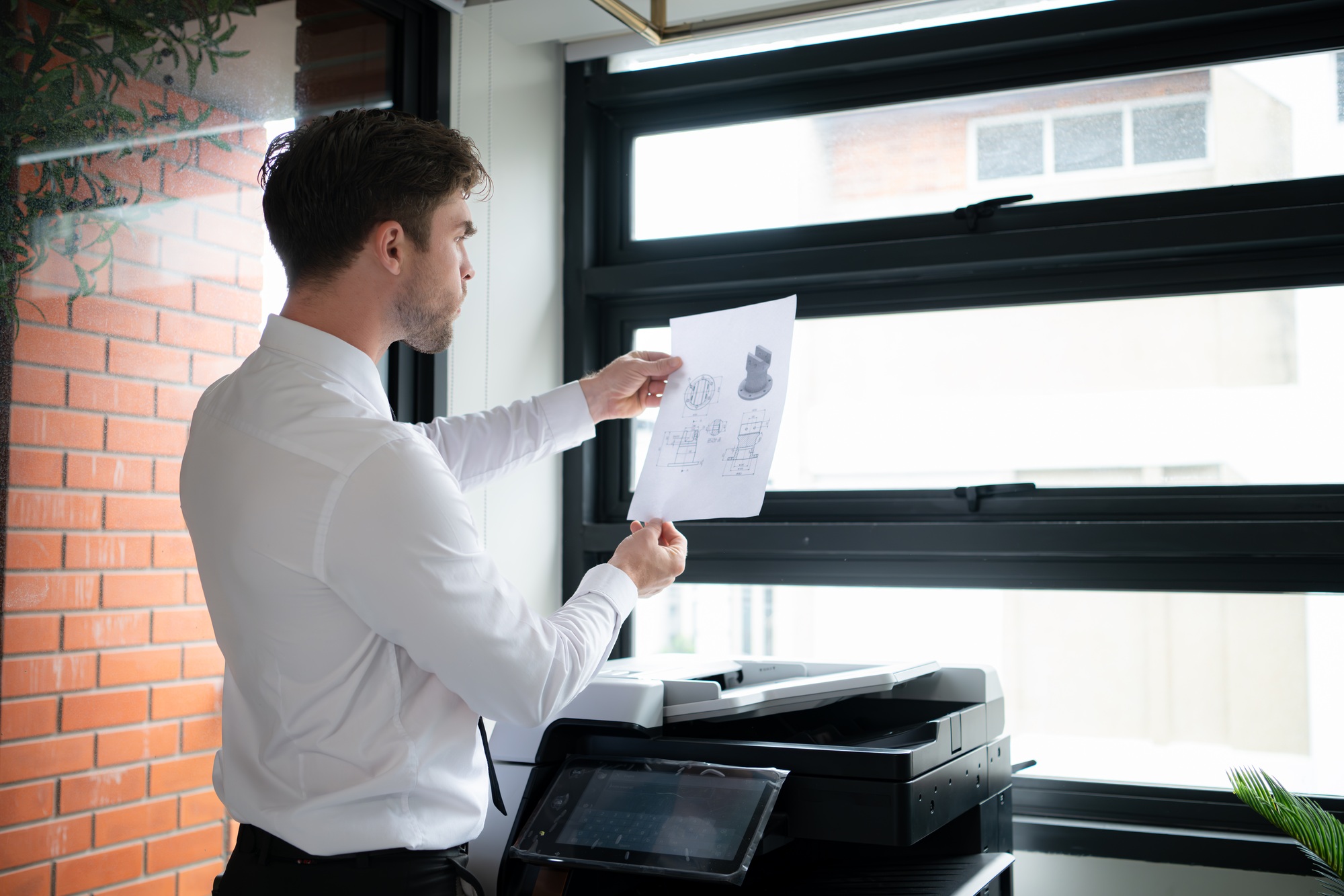 Businessman in office working with copier.