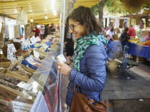 Young woman buying fresh food at market stall